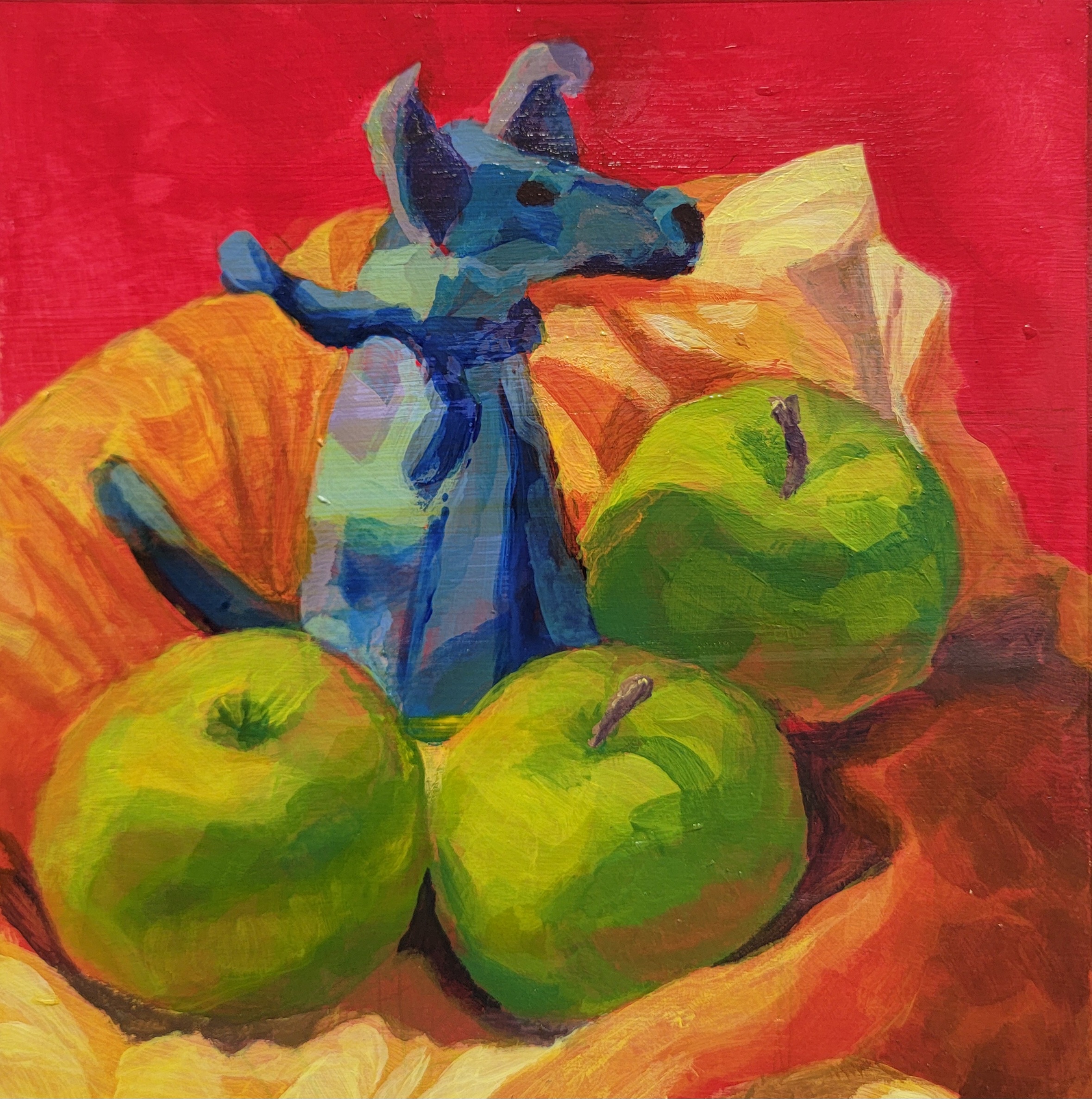 An observational painting of a blue felted dog and three green apples on top of an orange cloth, against a red background.